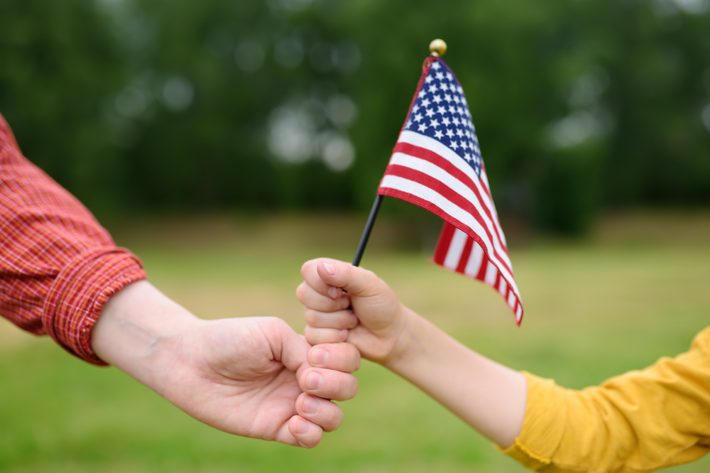 Young woman and little child holding american flag