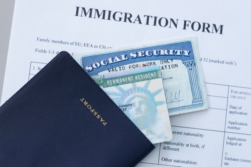 United States passport, social security card and permanent resident (green) card on immigration form. Application to register permanent residence.